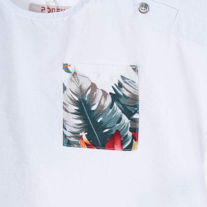 White tropical themed shirt, buttoned shoulder strap, front pocket. Back hem slightly longer than the front. Logo tag attached. 