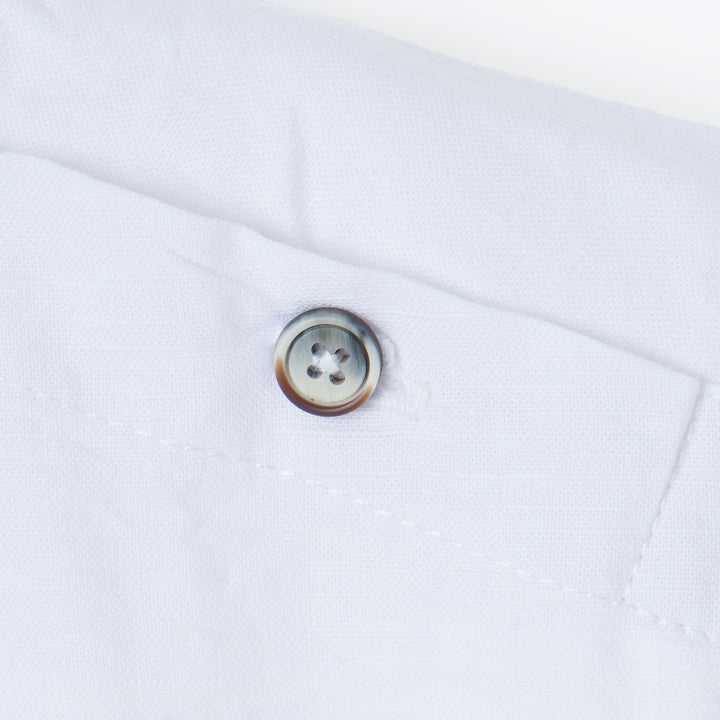 White tropical themed shirt, buttoned shoulder strap, front pocket. Back hem slightly longer than the front. Logo tag attached. 