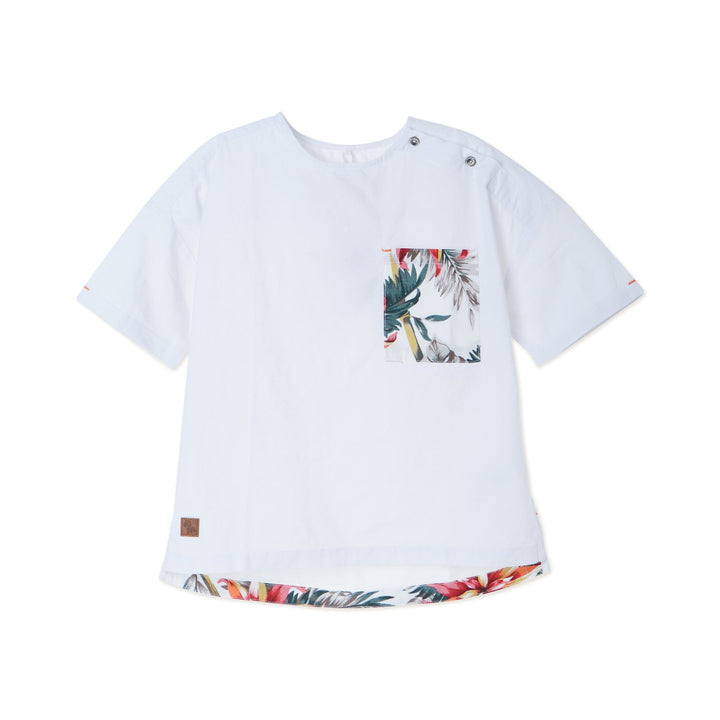 White tropical themed shirt, buttoned shoulder strap, front pocket. Back hem slightly longer than the front. Logo tag attached. 