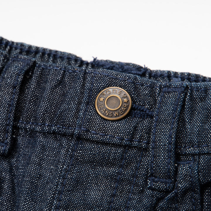 Elasticated dark blue jeans, skeletal dinosaur embroidered one leg front. Embossed caption on other leg front, metallic button fastening.