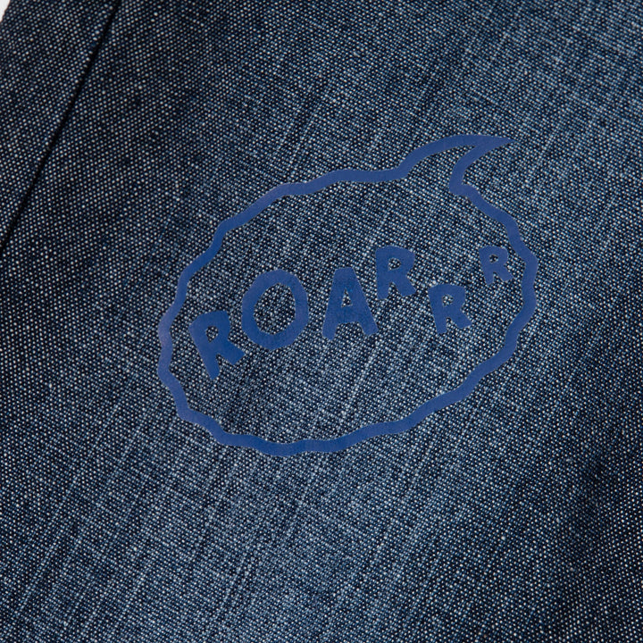 Elasticated dark blue jeans, skeletal dinosaur embroidered one leg front. Embossed caption on other leg front, metallic button fastening.