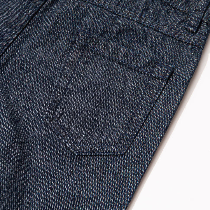 Elasticated dark blue jeans, skeletal dinosaur embroidered one leg front. Embossed caption on other leg front, metallic button fastening.