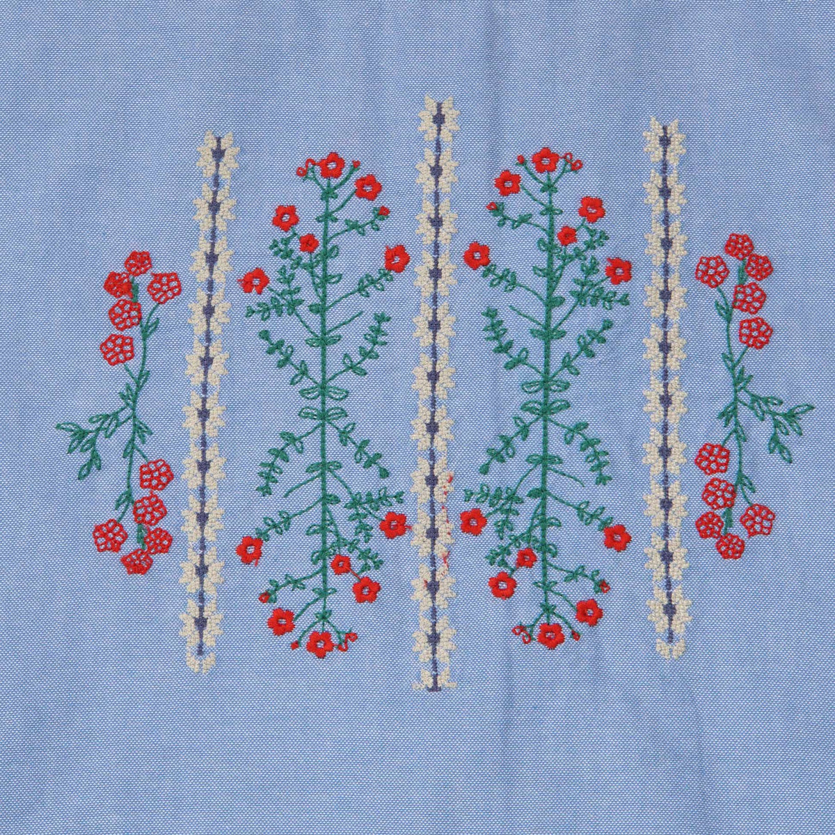 Cropped blue, short sleeves blouse, floral embroidery in the centre. Back fastened by buttons. 