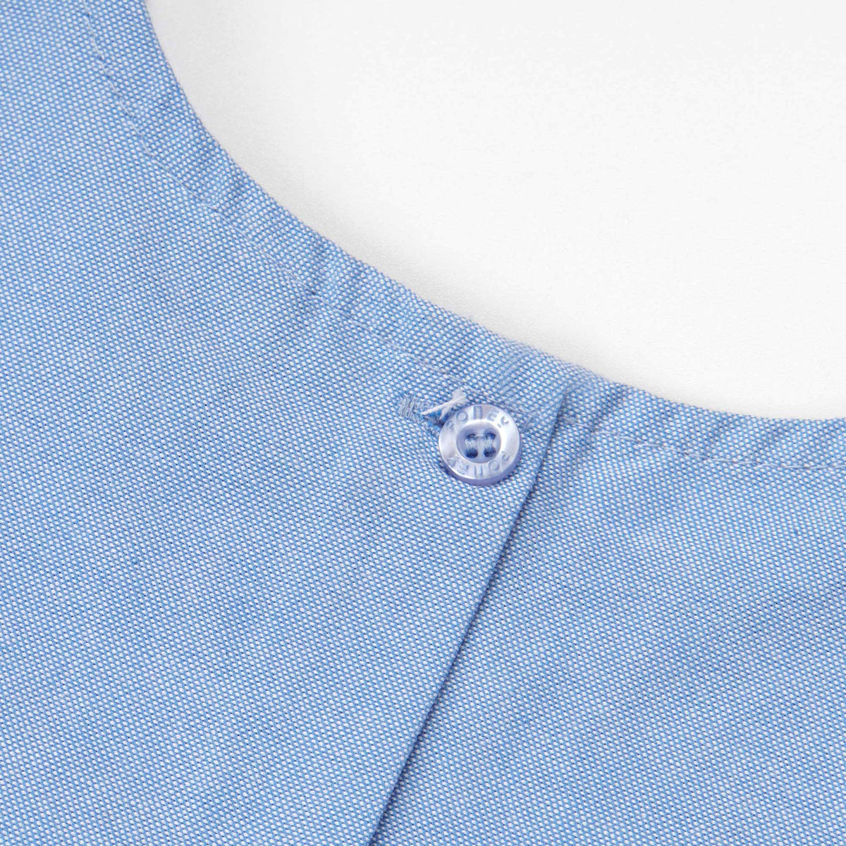 Cropped blue, short sleeves blouse, floral embroidery in the centre. Back fastened by buttons. 