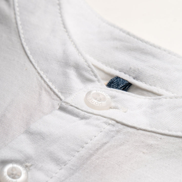 White fish tank shirt, short sleeve, front fastening. Back hem slightly longer than the front. 