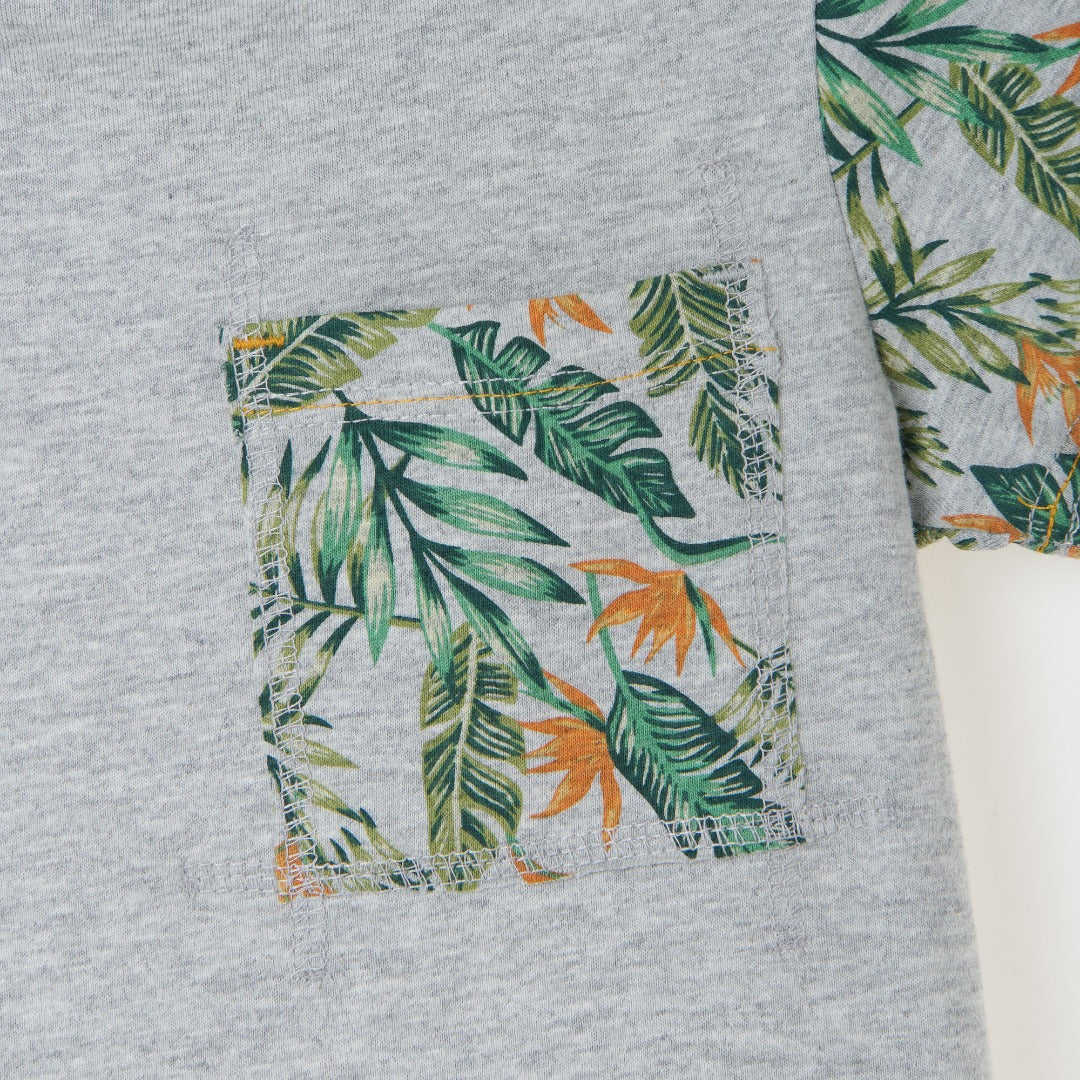 Melange top, short sleeve, beautiful tropical leaves design on sleeves and pocket. Buttoned shoulder strap, a logo strap on the bottom. 