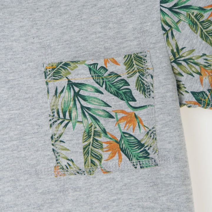 Melange top, short sleeve, beautiful tropical leaves design on sleeves and pocket. Buttoned shoulder strap, a logo strap on the bottom. 