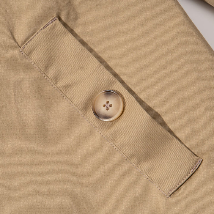 A khaki caped coat. Two buttoned pockets included as well as three fastening faded buttons at the front. 